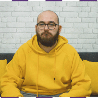 Bearded Man In Glasses And Yellow Hoodie Sitting On Couch GIF