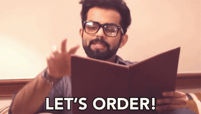Bearded Man In Glasses Reading Book Says Let's Order GIF