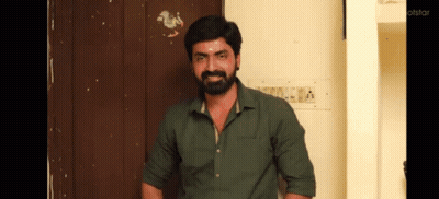Bearded Man In Green Shirt Standing In Front Of Door GIF