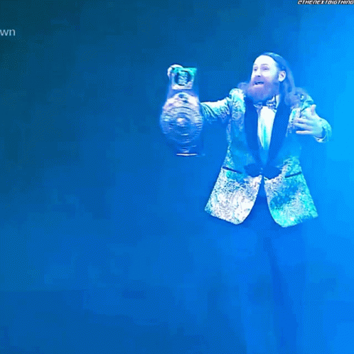 Bearded Man In Green Suit Holding Trophy GIF