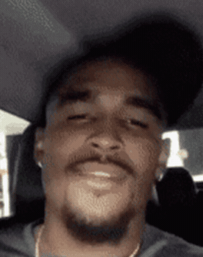 Bearded Man In Hat And Earbuds Smiling In Car GIF