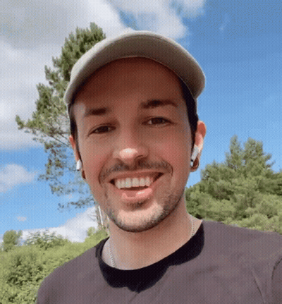 Bearded Man In Hat And Earbuds Smiling GIF