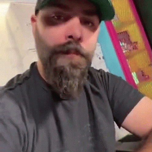 Bearded Man In Hat And Gray Shirt Taking Selfie GIF