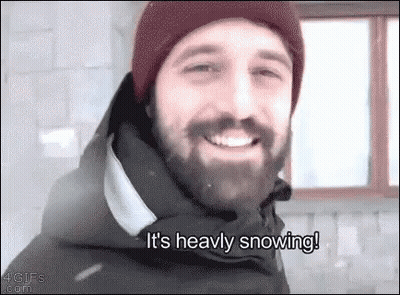 Bearded Man In Hat And Jacket Smiling In Snow GIF