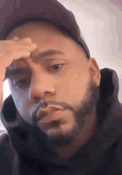 Bearded Man In Hat Holding Forehead Smoking Cigarette GIF