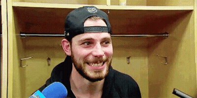 Bearded Man In Hat Holding Microphone In Locker Room GIF