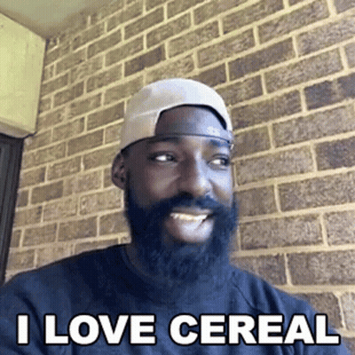 Bearded Man In Hat Smiling In Front Of Brick Wall GIF