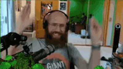 Bearded Man In Headphones Wearing Giant Shirt At Microphone GIF