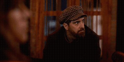 Bearded Man In Plaid Hat Looking At Camera GIF