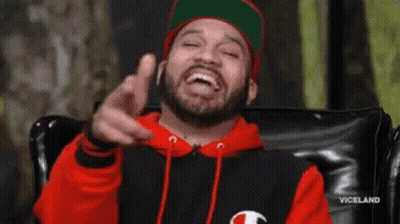 Bearded Man In Red Hoodie And Green Hat Pointing GIF