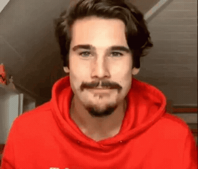 Bearded Man In Red Hoodie Looking At Camera GIF