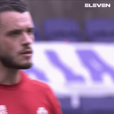 Bearded Man In Red Shirt In Front Of Stadium GIF