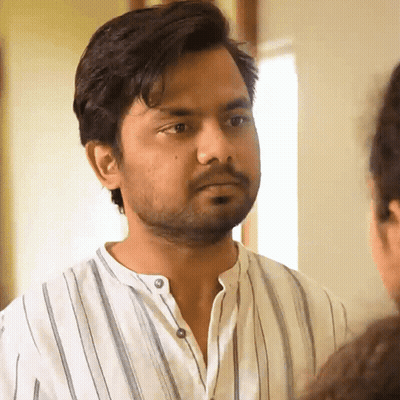 Bearded Man In Striped Shirt Looking At Another Man GIF