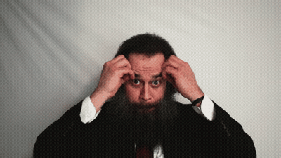 Bearded Man In Suit Adjusts Hair GIF