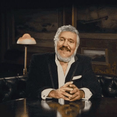 Bearded Man In Suit Sitting With Folded Hands GIF