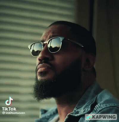 Bearded Man In Sunglasses And Denim Jacket Looking Up GIF