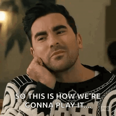 Bearded Man In Sweater Hand On Chin At Table GIF