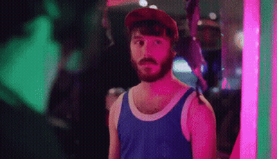 Bearded Man In Tank Top And Hat In Front Of Neon Sign GIF