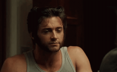 Bearded Man In Tank Top Looking In Mirror GIF