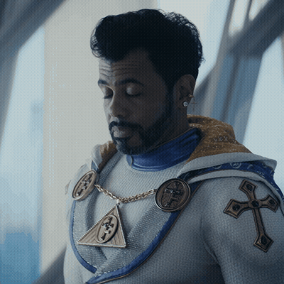Bearded Man In White And Blue Outfit With Cross GIF