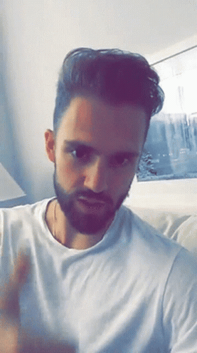 Bearded Man In White T-Shirt On Couch GIF