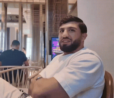 Bearded Man In White T-Shirt Sitting In Chair GIF