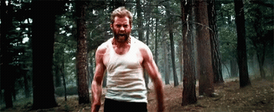Bearded Man In White Tank Top Walking Through Forest GIF