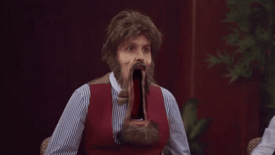 Bearded Man In Wig With Mouth Wide Open At Table GIF