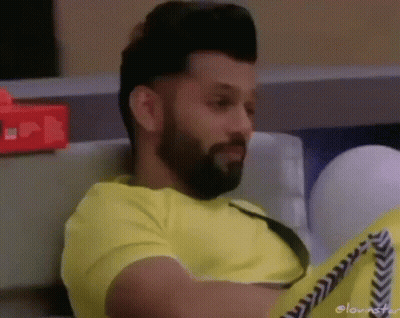 Bearded Man In Yellow Shirt Sitting On Couch GIF