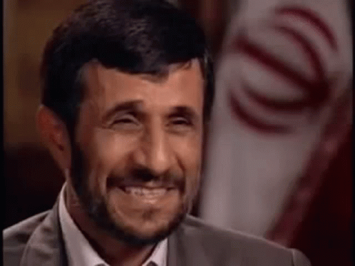 Bearded Man Laughing In Front Of Flag GIF