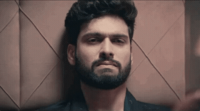Bearded Man Laying Down Looking At Camera GIF