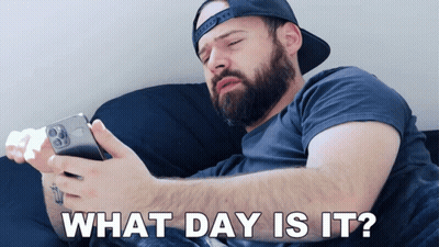 Bearded Man Laying On Couch Looking At Phone Saying What Day Is It GIF