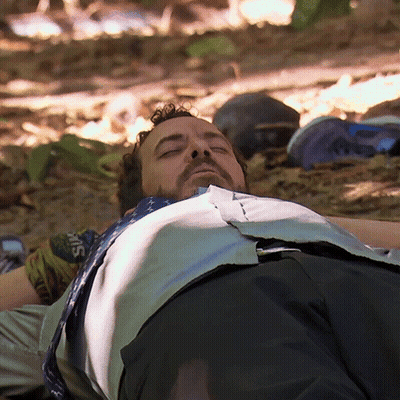 Bearded Man Laying On Ground Eyes Closed Shirt Saying Guns GIF
