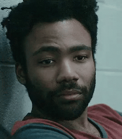 Bearded Man Leaning Against Brick Wall GIF