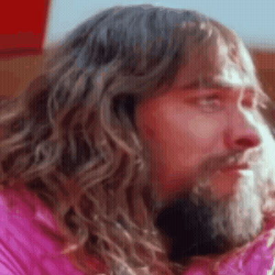 Bearded Man Long Hair Pink Jacket Looking Camera GIF