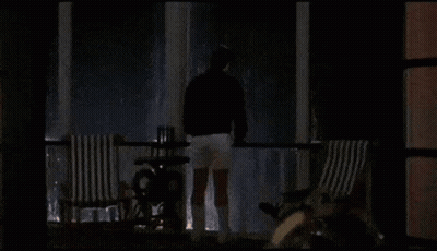 Bearded Man Looking At Camera In Dark Room GIF