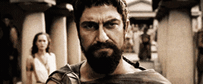 Bearded Man Looking At Camera With Woman In Background GIF