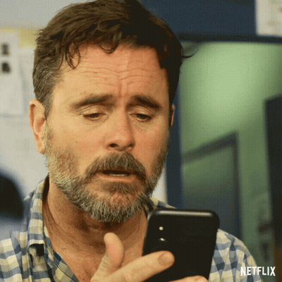 Bearded Man Looking At Phone With Netflix Logo GIF