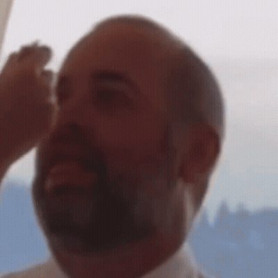Bearded Man Looking Up With Woman Holding His Hand GIF