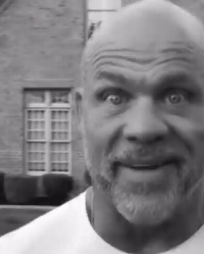Bearded Man Making Funny Face In Front Of Brick Building GIF