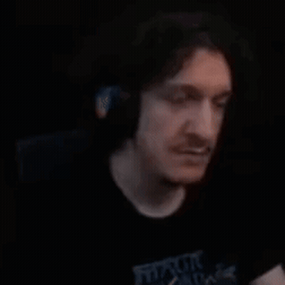 Bearded Man Making Hand Gesture In Dark Room GIF