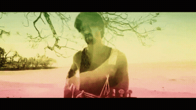 Bearded Man On Beach With Rainbow Background GIF
