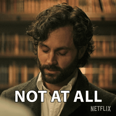 Bearded Man Says Not At All In Front Of Bookshelf GIF