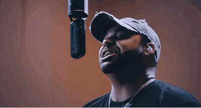 Bearded Man Singing Into Microphone In Studio GIF