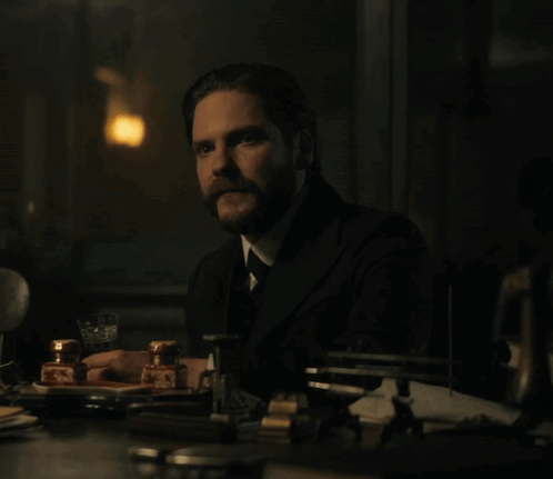Bearded Man Sits At Table GIF