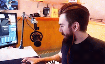 Bearded Man Sitting At Computer With Microphone GIF