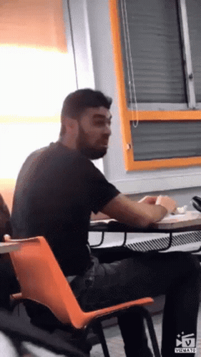 Bearded Man Sitting At Desk In Classroom GIF