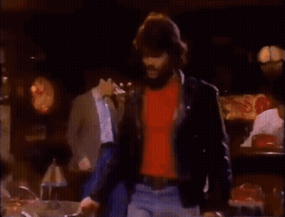 Bearded Man Sitting At Table Talking To Woman GIF