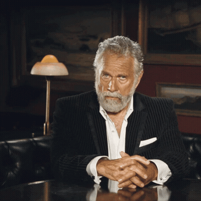 Bearded Man Sitting At Table With Folded Hands GIF