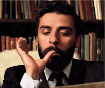 Bearded Man Sitting By Bookshelf GIF